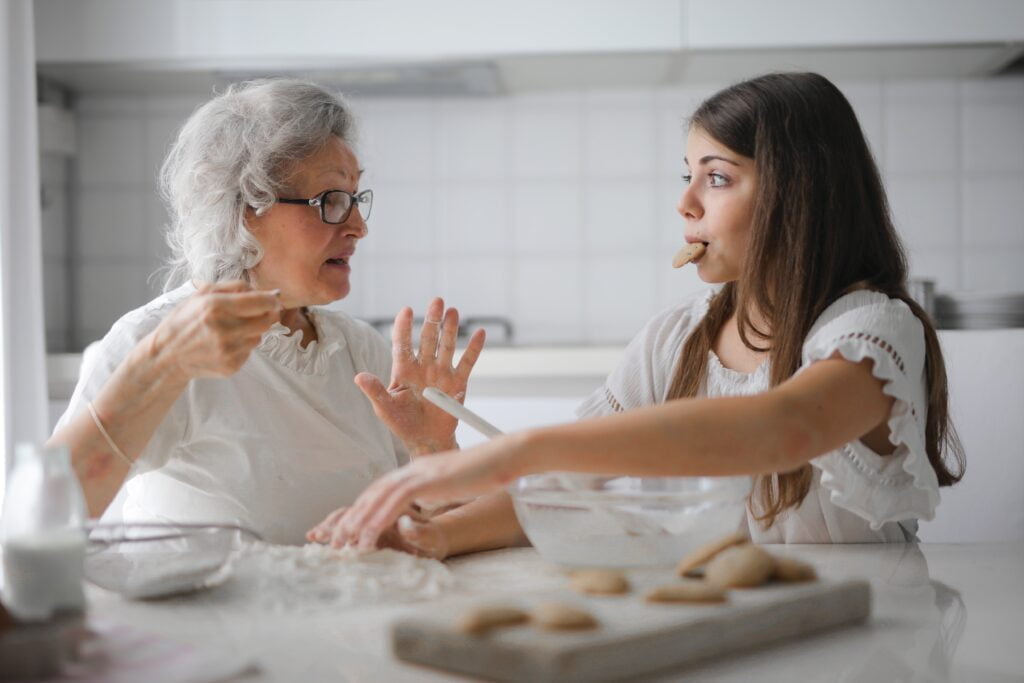 In-home care giver baking cookies with senior